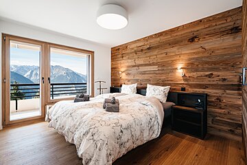 A bedroom with a bed and a view of the mountains