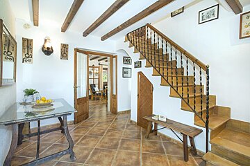 A hallway with stairs and a table with lemons on it
