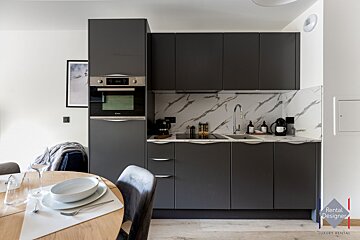 A kitchen with a rental designer logo on the corner