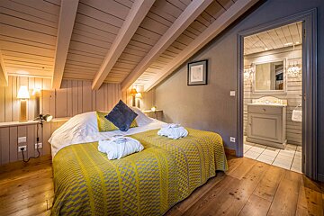 A bedroom with a bed and a bathroom with a sink