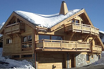 A large wooden house with snow on the roof