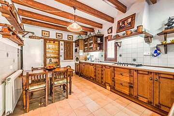 A kitchen with wooden cabinets and a table and chairs