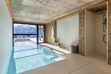 A large indoor swimming pool with a view of the mountains