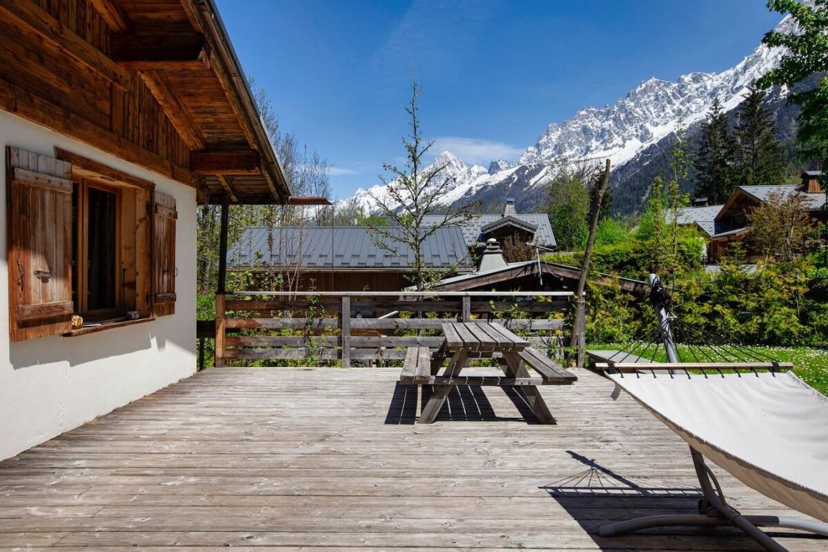 A wooden deck with a picnic table and hammock