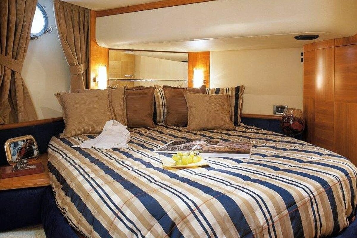 A bed with a striped comforter and a magazine on it