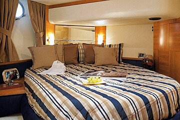 A bed with a striped comforter and a magazine on it