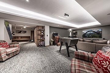 A living room with a couch and a pinball machine