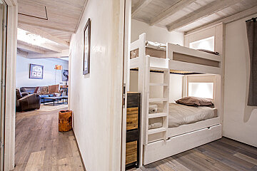 A bunk bed in a hallway leading to a living room