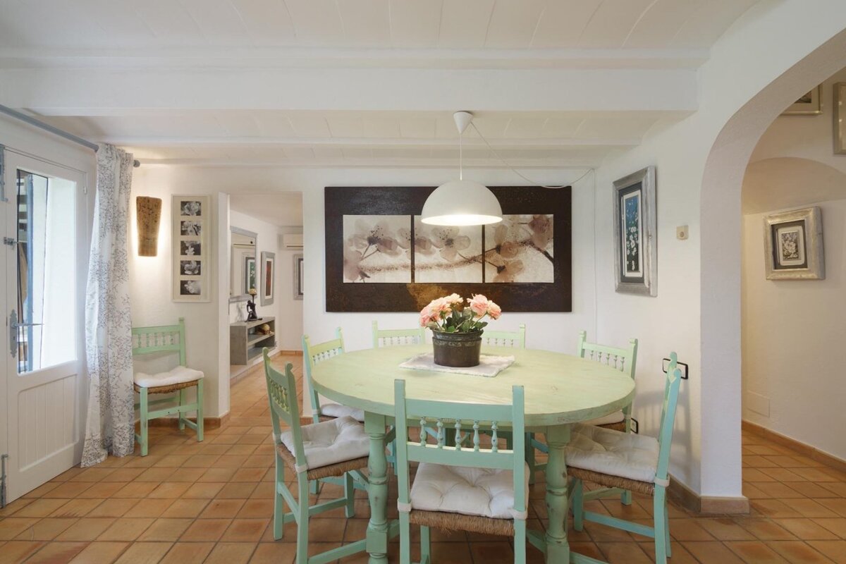 A dining room with a green table and chairs