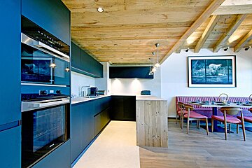A kitchen with blue cabinets and a picture of a polar bear on the wall