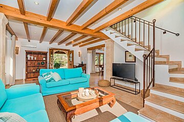 A living room with a blue couch and a flat screen tv