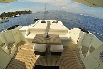 The back of a boat with a table and chairs on it