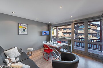 A living room with a poster on the wall that says cosmopole