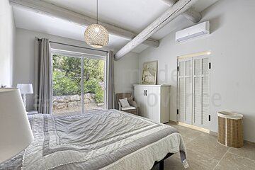 A bedroom with a large bed and a sliding glass door