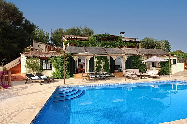 A large house with a swimming pool in front of it