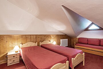 A bedroom with a bed a radiator and a window