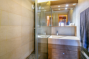 A bathroom with a sink and a walk in shower