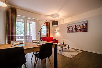 A living room with a painting of cows on the wall