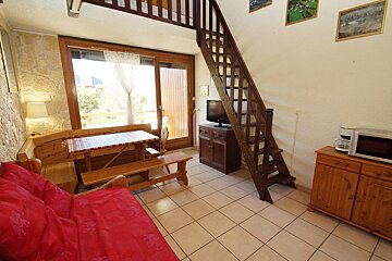 A living room with a staircase leading up to the second floor