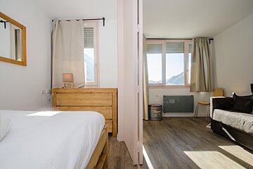 A bedroom with a bed a dresser and a couch