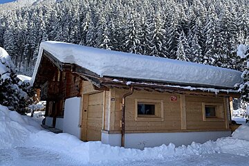 A snowy cabin with a red sign on the side that says ' alquiler '
