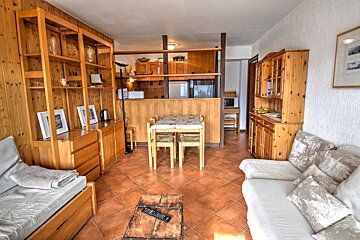 A living room with a couch and a table and chairs