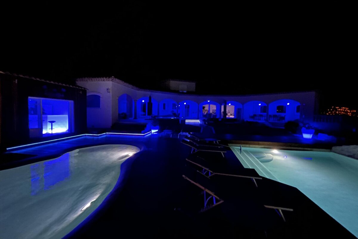 A large swimming pool is lit up at night