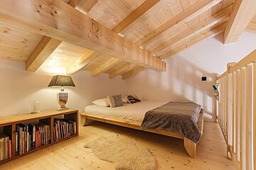 An attic bedroom with a bed and a lamp