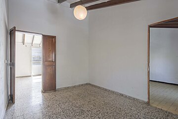 An empty room with a light hanging from the ceiling