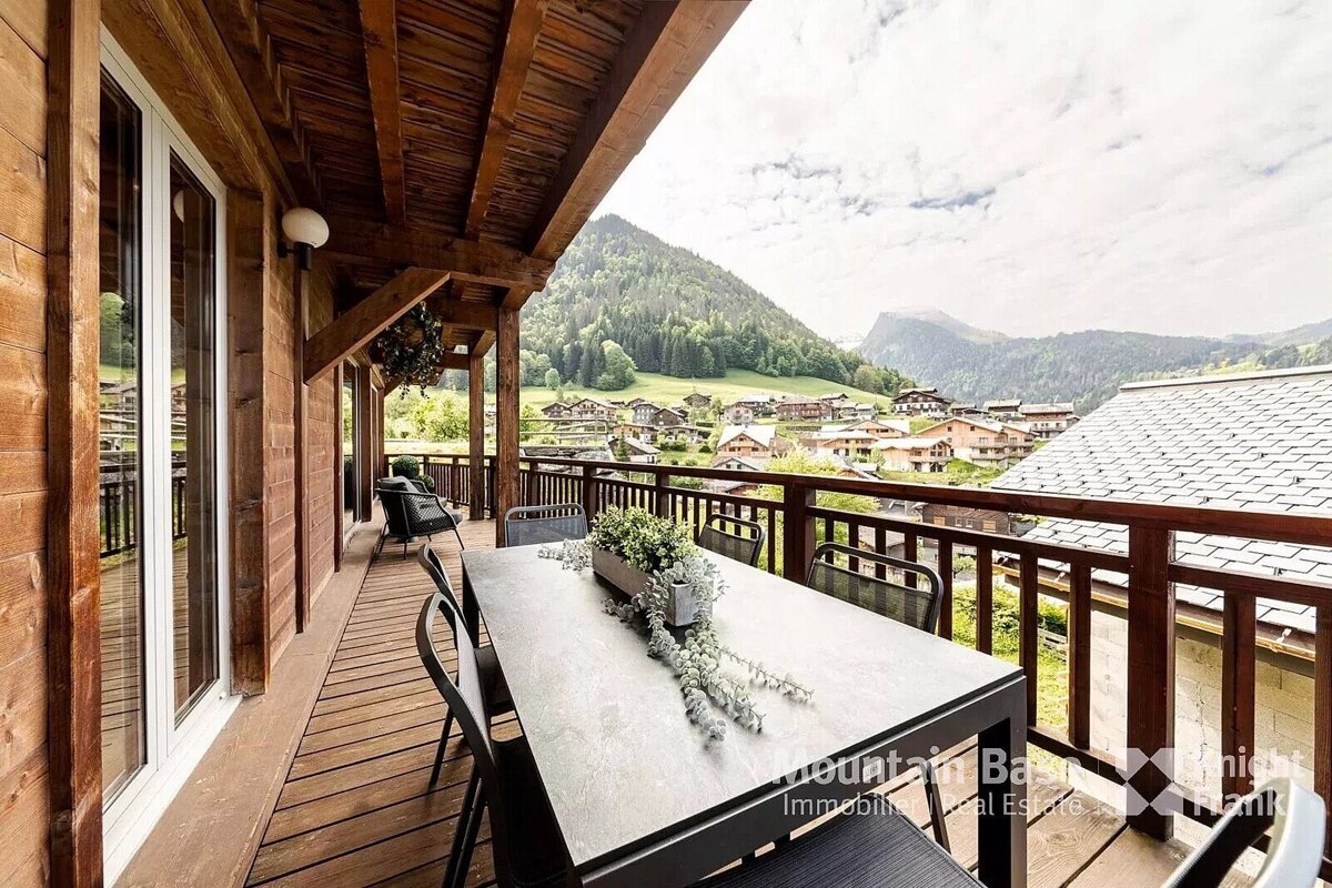 A balcony with a table and chairs and the word mountain below it