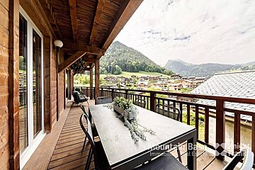 A balcony with a table and chairs and the word mountain below it