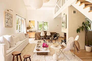 A living room with a white couch and a white coffee table