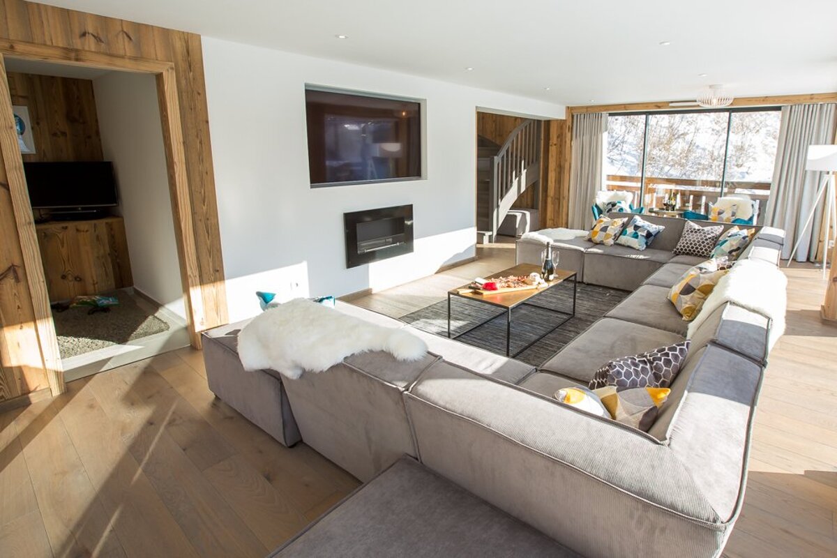 A living room with a large sectional couch and a flat screen tv