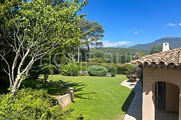 A house with a large lawn and mountains in the background