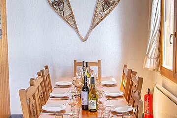 A long table with plates and wine bottles on it