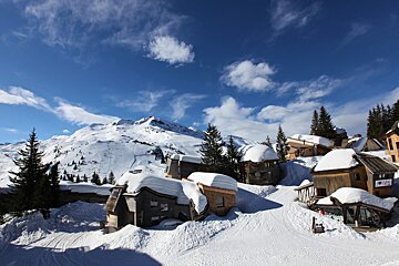 A snowy village with a sign that says ' l' ermitage ' on it