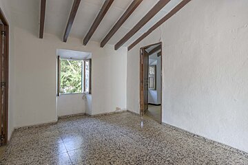 An empty room with a window and wooden beams