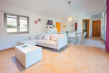 A living room with a white couch and a white coffee table