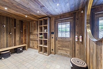 A wooden hallway with two fire extinguishers on the wall