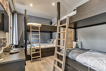 A bunk bed with a wooden ladder leading up to it