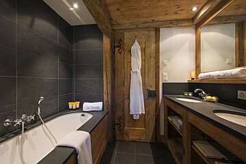 A bathroom with a bathtub and a towel that says le peche
