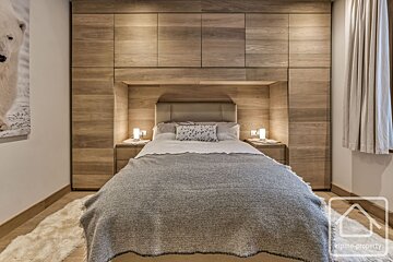 A bedroom with a bed and a picture of a polar bear on the wall