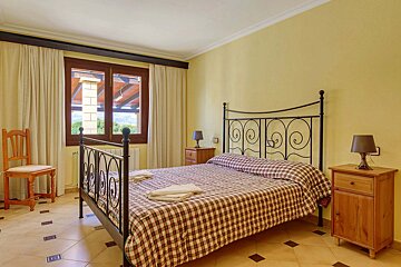 A bedroom with a wrought iron bed and two nightstands