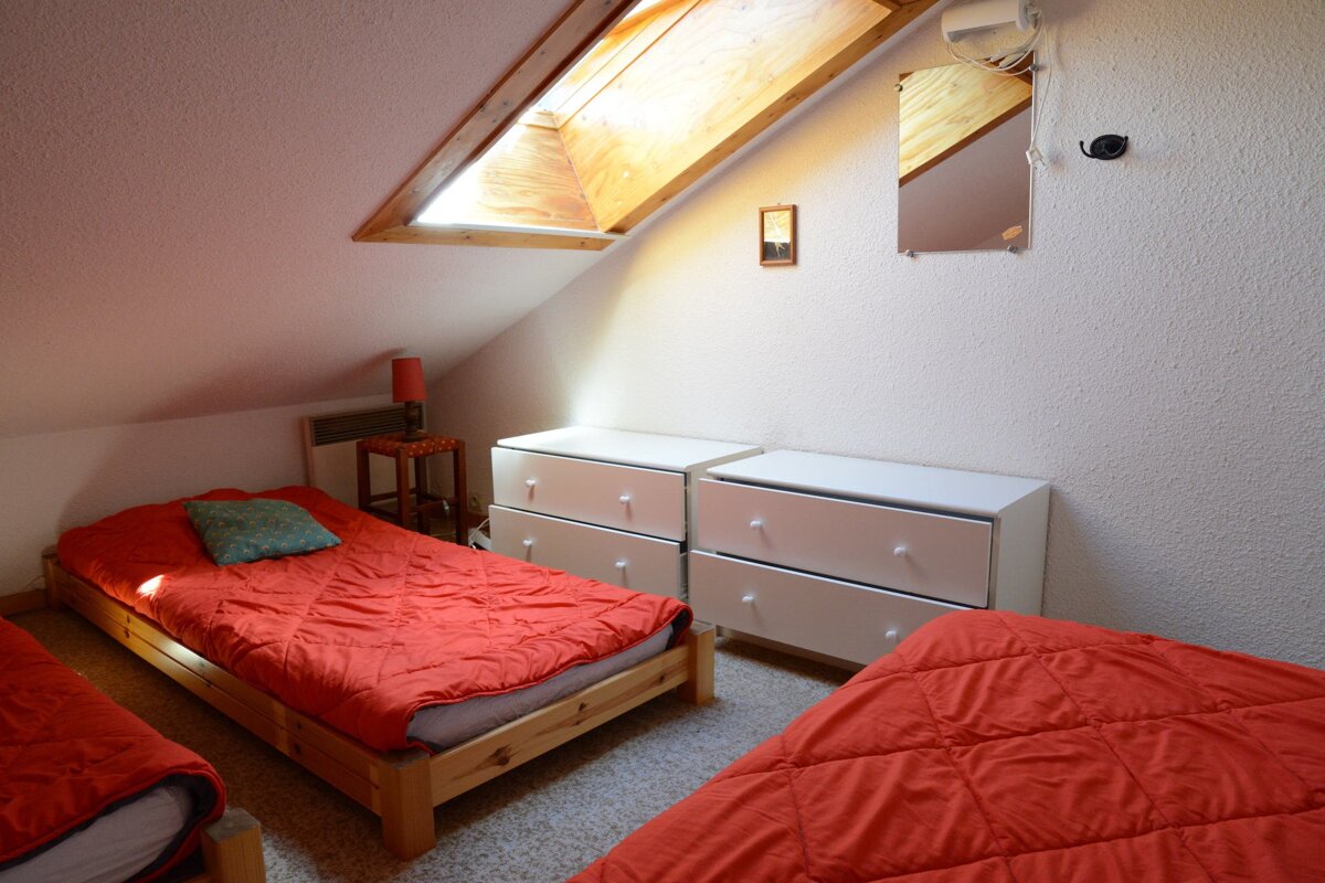 A bedroom with two beds and a dresser