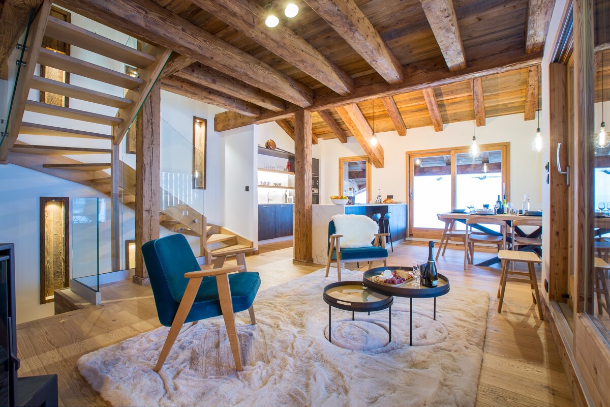 A living room with a blue chair and two tables