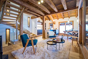 A living room with a blue chair and two tables