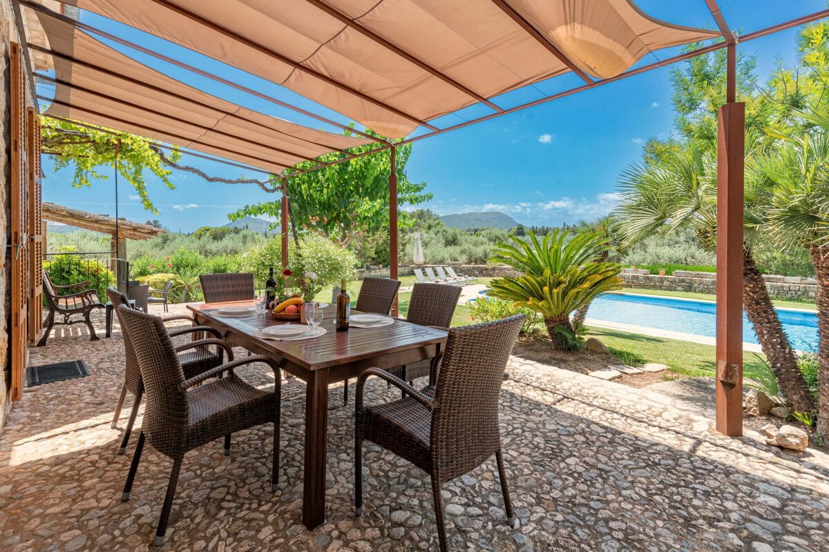 A patio with a table and chairs and a bottle of wine