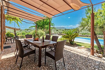 A patio with a table and chairs and a bottle of wine
