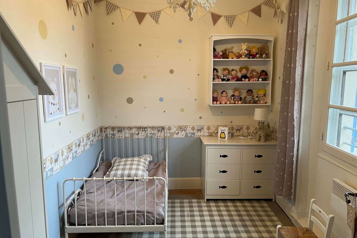 A bedroom with a bed and a dresser with fish drawers