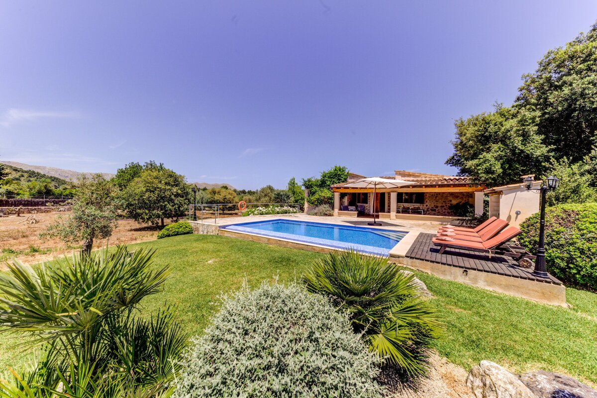 A house with a large swimming pool in front of it